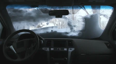 Clearing snow from a car windshield, interior view Stock Footage 33494974