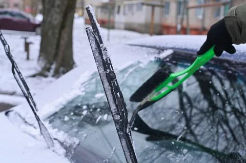 Clearing snow from the windshield of the car. close-up Stock Photos