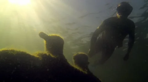 Cleat with backlight sun beams behind an old wrecked ship, snorkeling diver Stock Footage 55377596