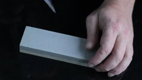 Cleaver narrow knife sharpening on Whetstone on background of black boards. Stock-Footage 123882700