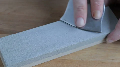 Cleaver narrow knife sharpening on Whetstone on background of wooden boards. Stock-Footage 123883165