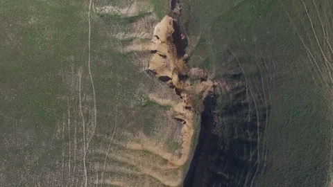 Cleft in the ground. A small canyon on a green lawn. Video stock 153022876