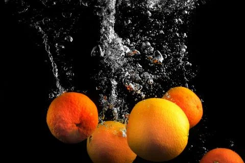 Clementines falling in water Stock Photos