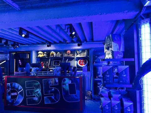 Clerk behind a blue-lit Marvel merchandise counter in a comic shop in Dubli.. Stock Photos