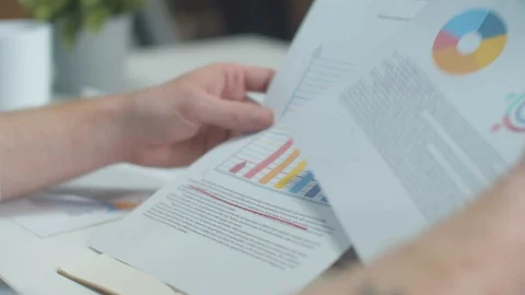 Clerk examines graphs and charts in a document Stock Footage 129951864