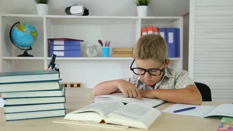 Clever boy with glasses reading a book and found the correct answer Stock Footage 82487528