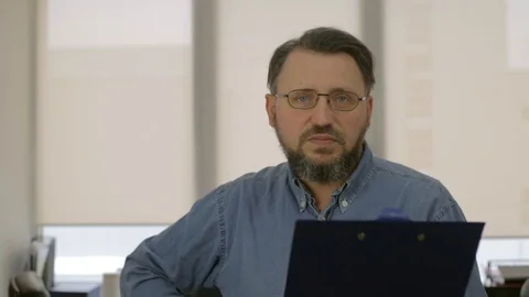 Clever man in glasses with tablet reading in office Stock Footage 97351674