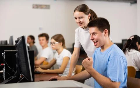 Clever students rejoicing solution of the task while using PC in the computer Foto stock