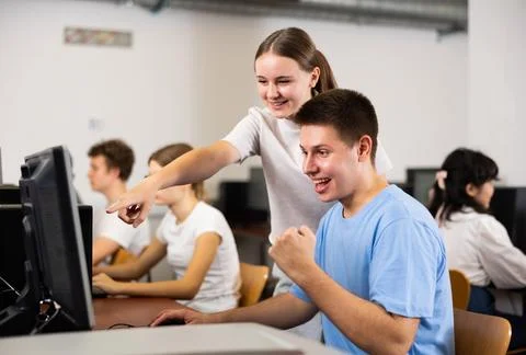Clever students rejoicing solution of the task while using PC in the computer Foto stock