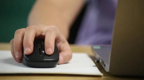 Click black computer mouse on a work desk. Working with a PC or laptop at w.. Stock Photos