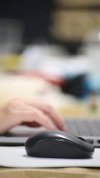 Click black computer mouse on a work desk. Working with a PC or laptop at w.. Stock Photos