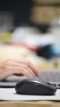 Click black computer mouse on a work desk. Working with a PC or laptop at w.. Stock Photos