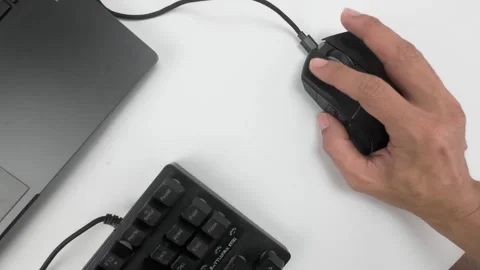 Clicking Computer Mouse on White Desk with Keyboard and Laptop Stock Footage 311795431