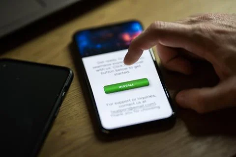 Clicking on green install button on smartphone Stock Photos