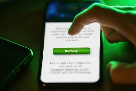Clicking on green install button on smartphone Stock Photos