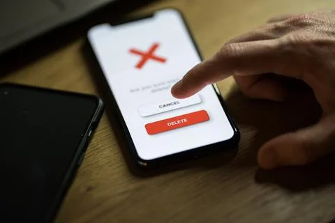 Clicking on red delete button on smartphone app Stock Photos