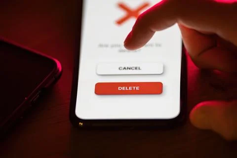 Clicking on red delete button on smartphone app Stock Photos
