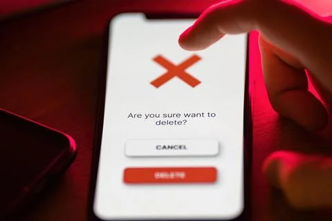 Clicking on red delete button on smartphone app Stock Photos