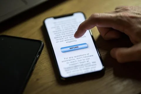 Clicking on refund button on smartphone app Stock Photos