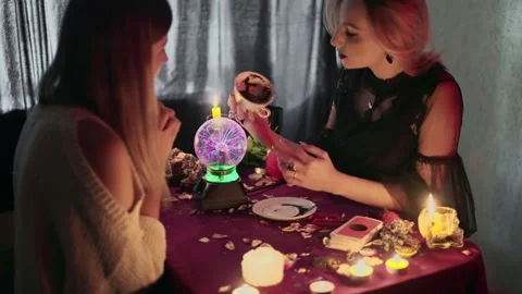 Client and fortune teller holding empty cup with coffee grounds and reading Vídeos de archivo 143513803