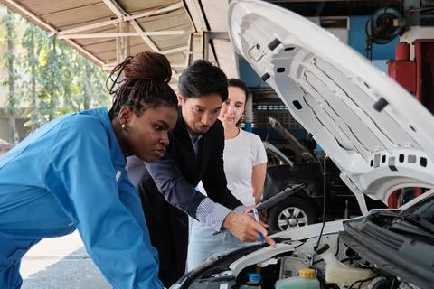 Client and manager discussed Black female mechanic for claim warranty at garage. Stock Photos