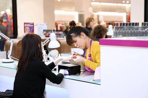 Client and the master of Express manicure in the shopping center "well". Mosc Stock Photos