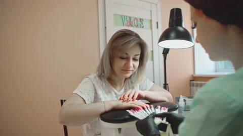The client chooses her own version in the palette of nail paints. Stock Footage 152988832