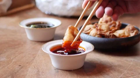Client dipping a fried dumpling in a spicy sauce Stock Footage 203897431