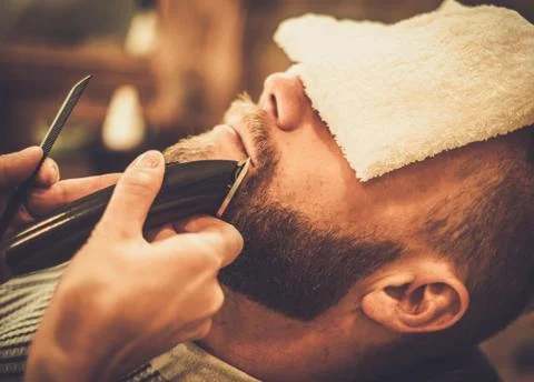 Client during beard and moustache grooming in barber shop Stock Photos