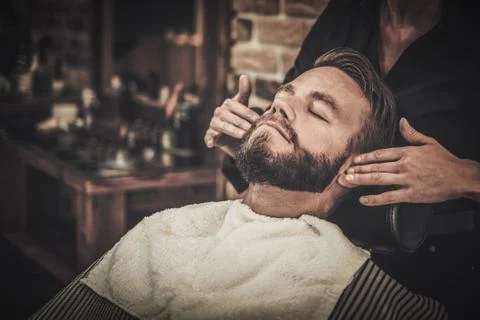 Client during beard and moustache grooming in barber shop Stock Photos
