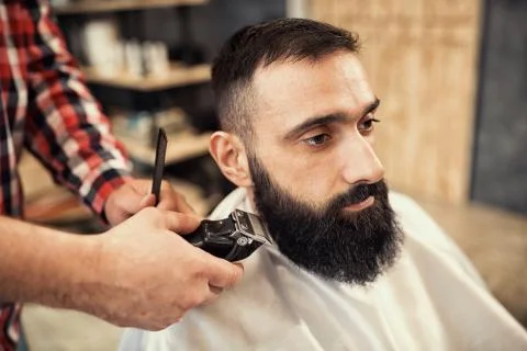 Client during beard and moustache grooming in barber Stock Photos