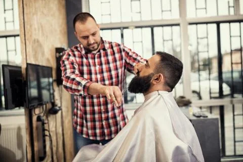 Client during beard and moustache grooming in barber 库存照片