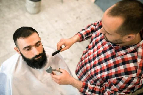 Client during beard and moustache grooming at barber shop Stock Photos