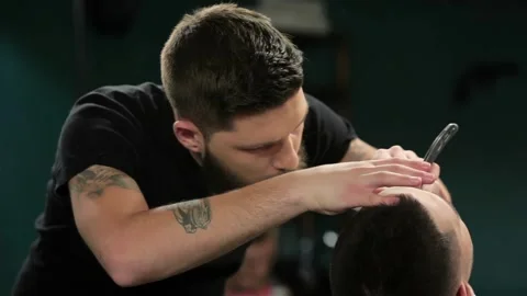 Client during beard grooming in barber shop Stock Footage 252661114