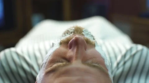 Client during beard shaving in barber shop Stock Footage 70952881