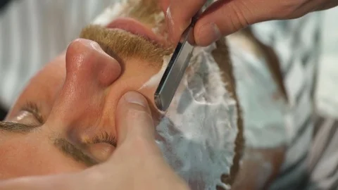 Client during beard shaving in barber shop Stock Footage 70953214