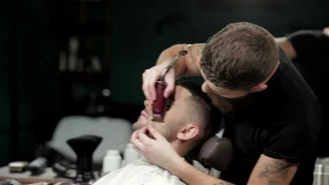 Client during beard shaving in barber shop Stock Footage 252660577