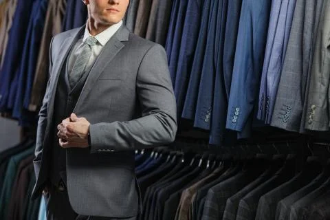 Client is elegant guy in jacket. In the background classic suits and jackets Stock Photos