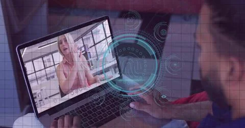 Client exercising at home while instructor in sportswear guiding via laptop w Stock Photos