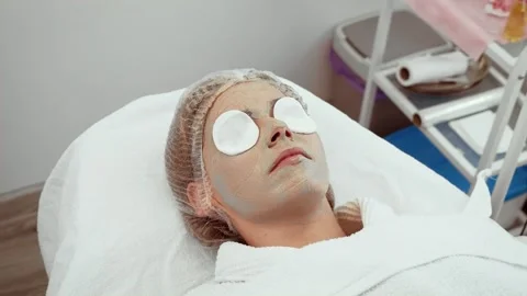 Client experiencing refreshing facial treatment at aesthetic center. Woman Stock Footage 303645441