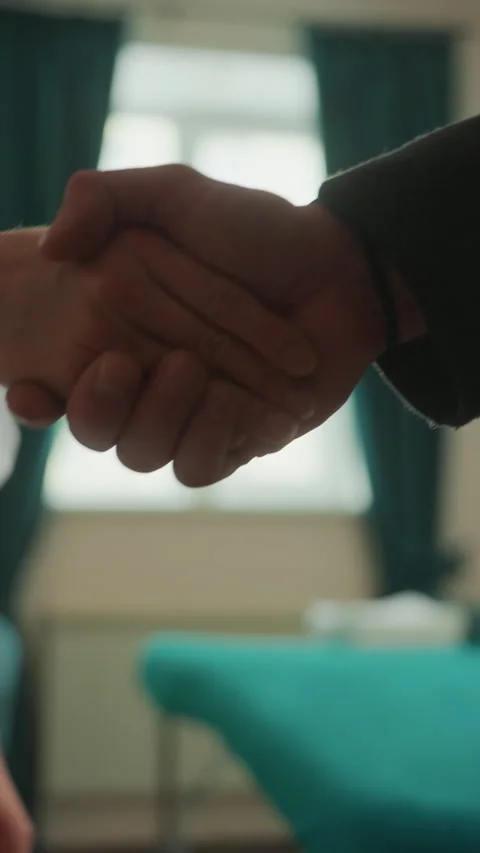 Client greets professionally. Visitor exchanges firm handshake respectfully 库存影片 331361688