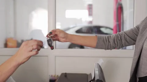 Client hands over car keys to service center representative for maintenance Stock Footage 270900035