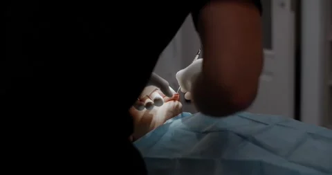 Client is having surgery by dentist surgeon in dental clinic Stock Footage 261056178