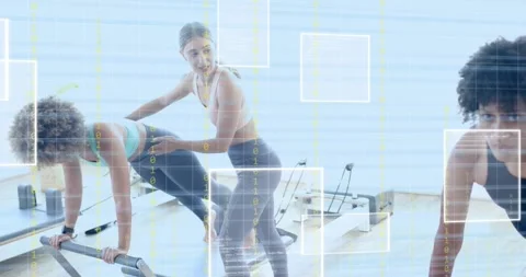 Client holding pilates plank, coach correcting posture, new client entering and Stock Footage 318739776