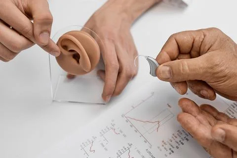 Client learns about hearing aids while examining ear anatomy with a profess.. Fotos Stock