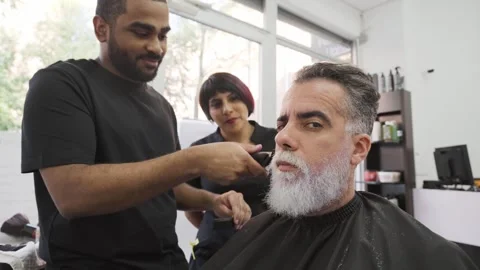 Client making faces and smirks at camera while stylists work on his beard.MOV 스톡 동영상 255795868