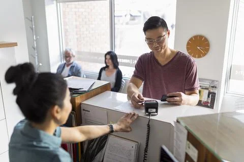 Client making payment with credit card at natural medicine clinic Stock Photos