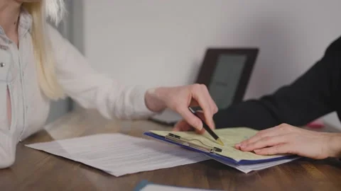 A client in the office signs a document with a pen. Signing of the lease Stock Footage 237066727
