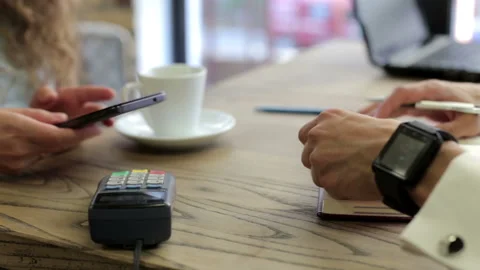 The client pays for coffee using NFC technology using a phone and smart watch. Stock Footage 154748843