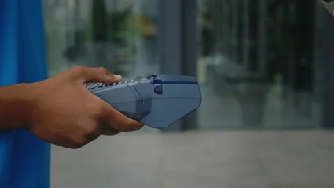 The Client Pays Package from Delivery Man Credit Card on Cash Machine. Online Stock Footage 237525368